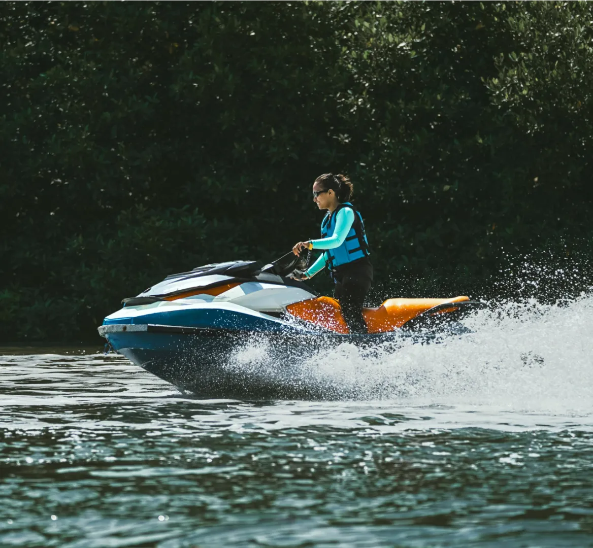 A photo of a women on a jet ski enjoying their vacation package from the fundraising auction.